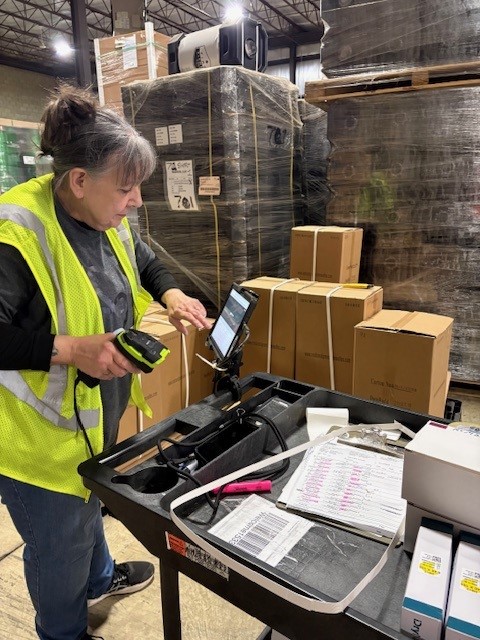 woman scanning boxes in warehouse