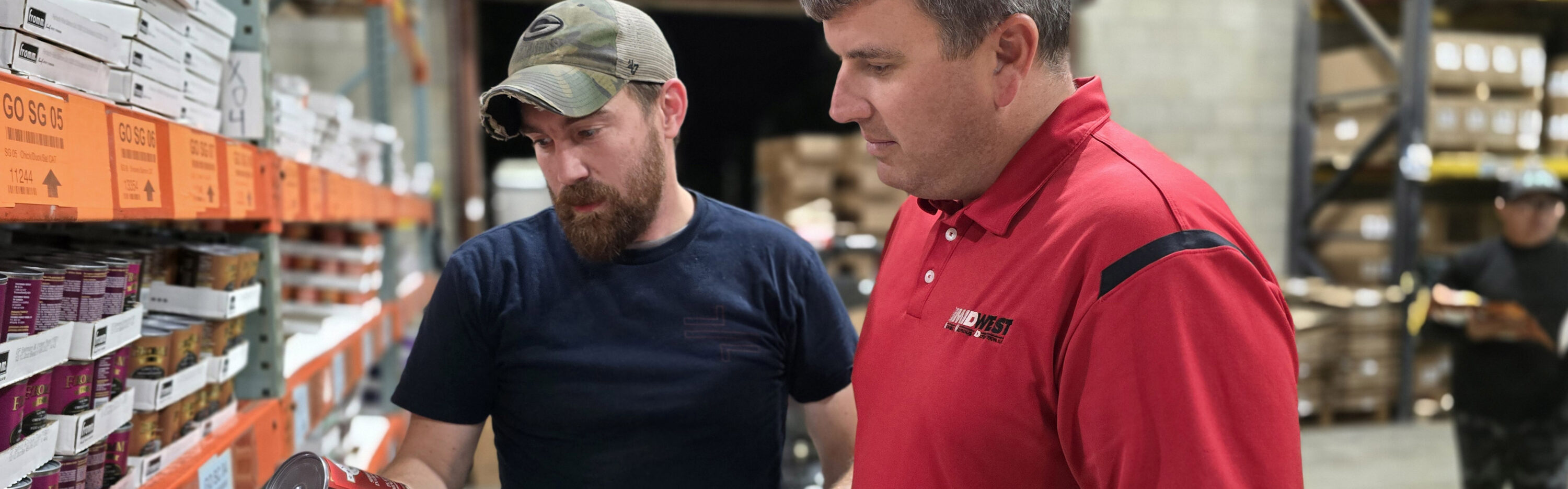 two men talking in warehouse about food product