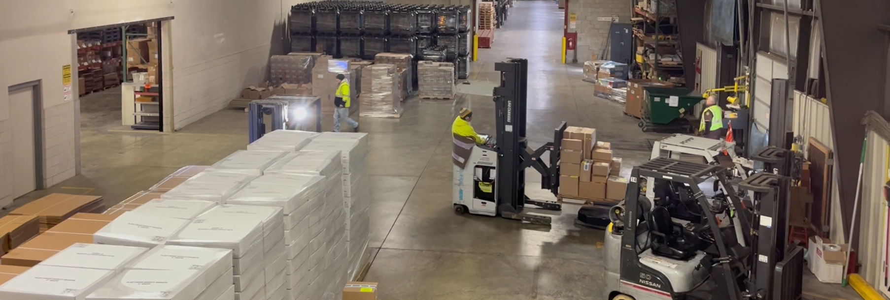 forklifts zipping around a busy warehouse