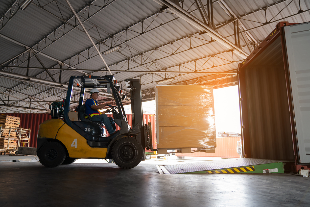 forklift moving boxes to another truck